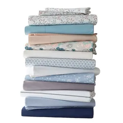 A stack of folded bed sheets in various colors and patterns, including floral and solid designs.