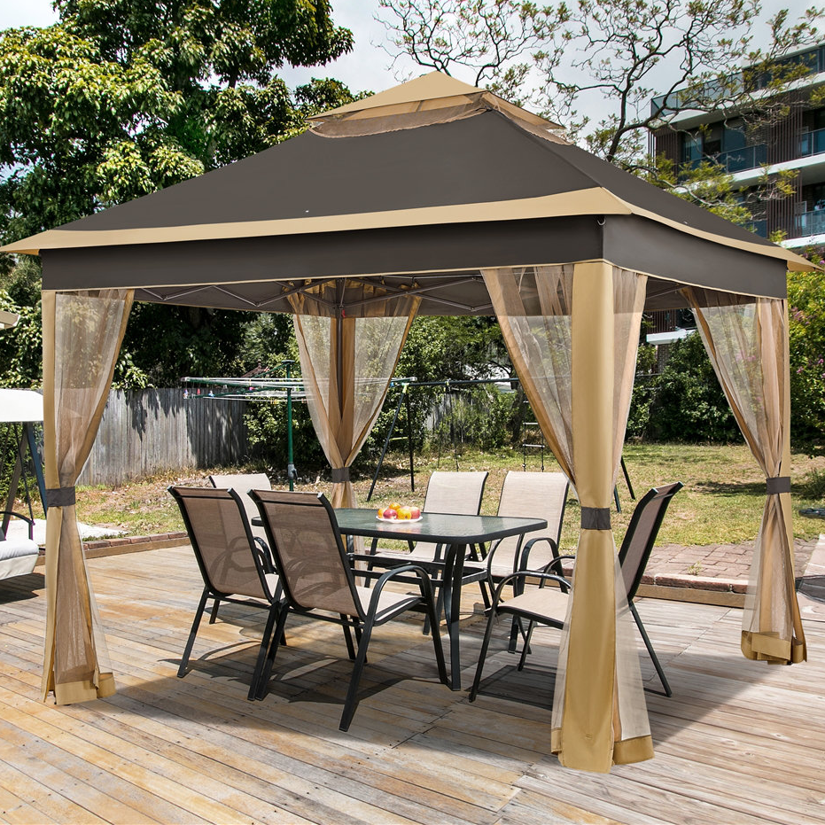 A backyard gazebo with a two-tier canopy and mesh curtains over a wooden deck, featuring a patio dining set with six chairs and a rectangular table.