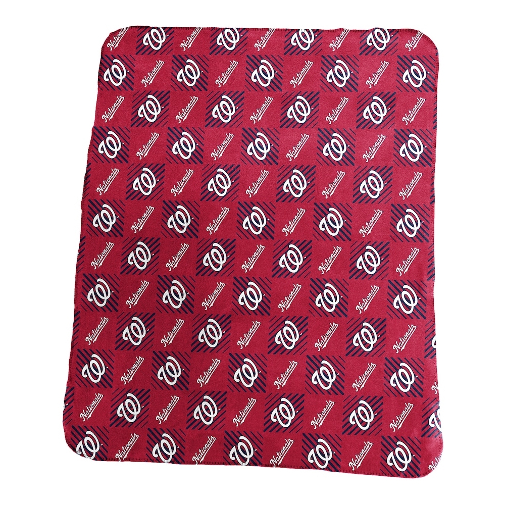 A red picnic blanket with a repeated white and black logo pattern.