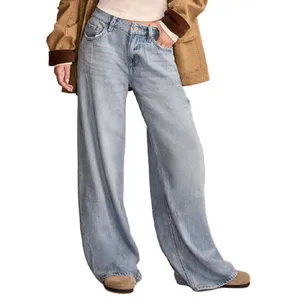 A person is wearing light blue wide-leg jeans, with a cream sweater and a brown jacket, along with tan shoes.