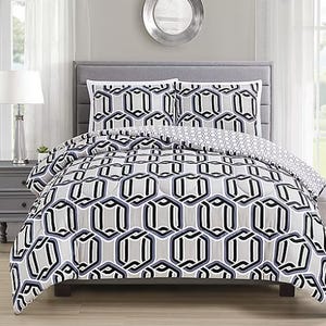A bedding set featuring a geometric hexagonal pattern in black, white, and grey, with matching pillowcases, displayed on a grey upholstered headboard bed.