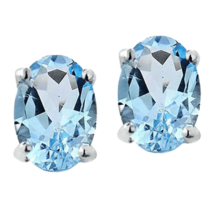 A pair of oval-cut, light blue gemstone earrings set in a four-prong silver setting.