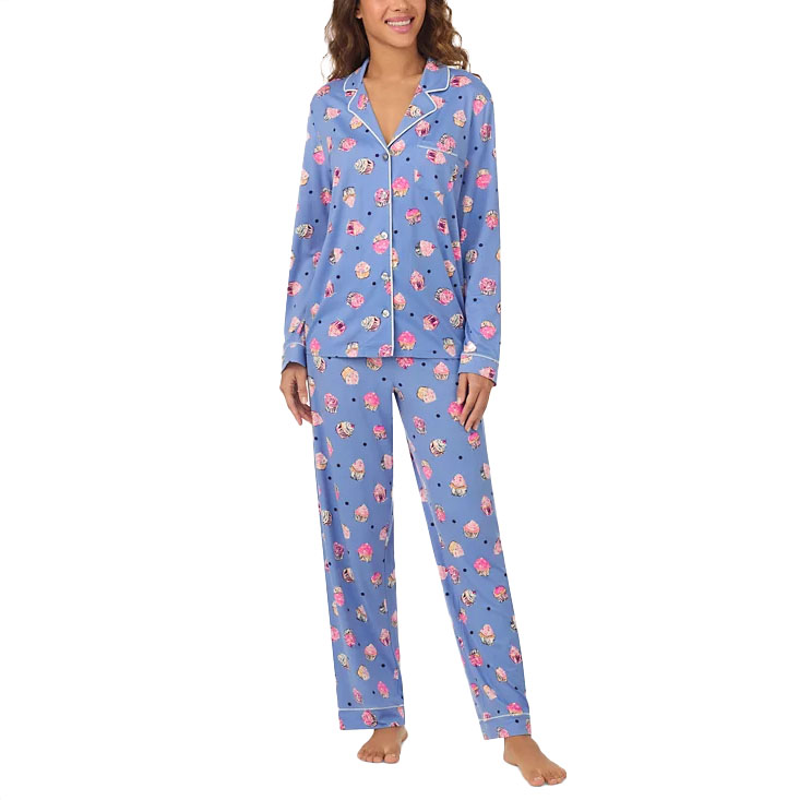 A women's pajama set featuring a blue background with a multicolored floral pattern. The set includes a long-sleeve button-up top with a collared neckline and matching pants.