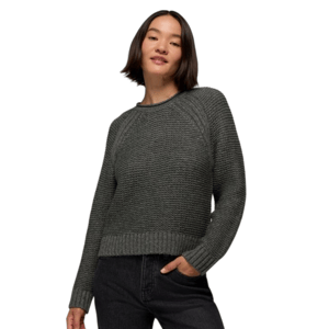 A woman is wearing a textured gray knit sweater with ribbed cuffs and hem, paired with dark jeans.