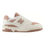 A New Balance sneaker in a beige and pink color scheme featuring a leather upper, perforated details, and a textured rubber sole.