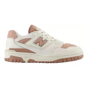 A New Balance sneaker in a beige and pink color scheme featuring a leather upper, perforated details, and a textured rubber sole.