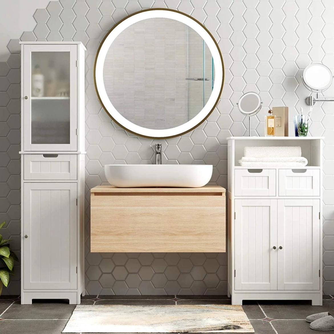 Modern bathroom setting with a wooden floating vanity, white ceramic vessel sink, circular LED mirror, hexagonal tile wall, and white cabinets for storage.