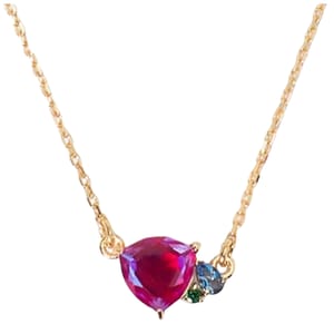 The Kate Spade Shine Me Up Pendant features a triangular red gemstone complemented by two smaller stones in blue and green, set on a delicate gold chain.
