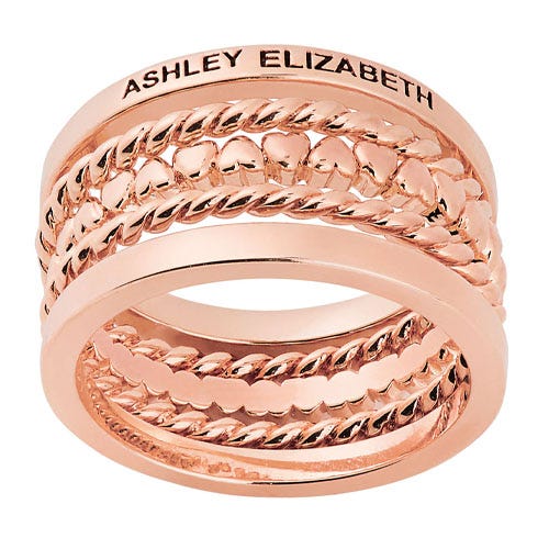 A rose-gold stacking ring set with the name Ashley Elizabeth inscribed at the top.