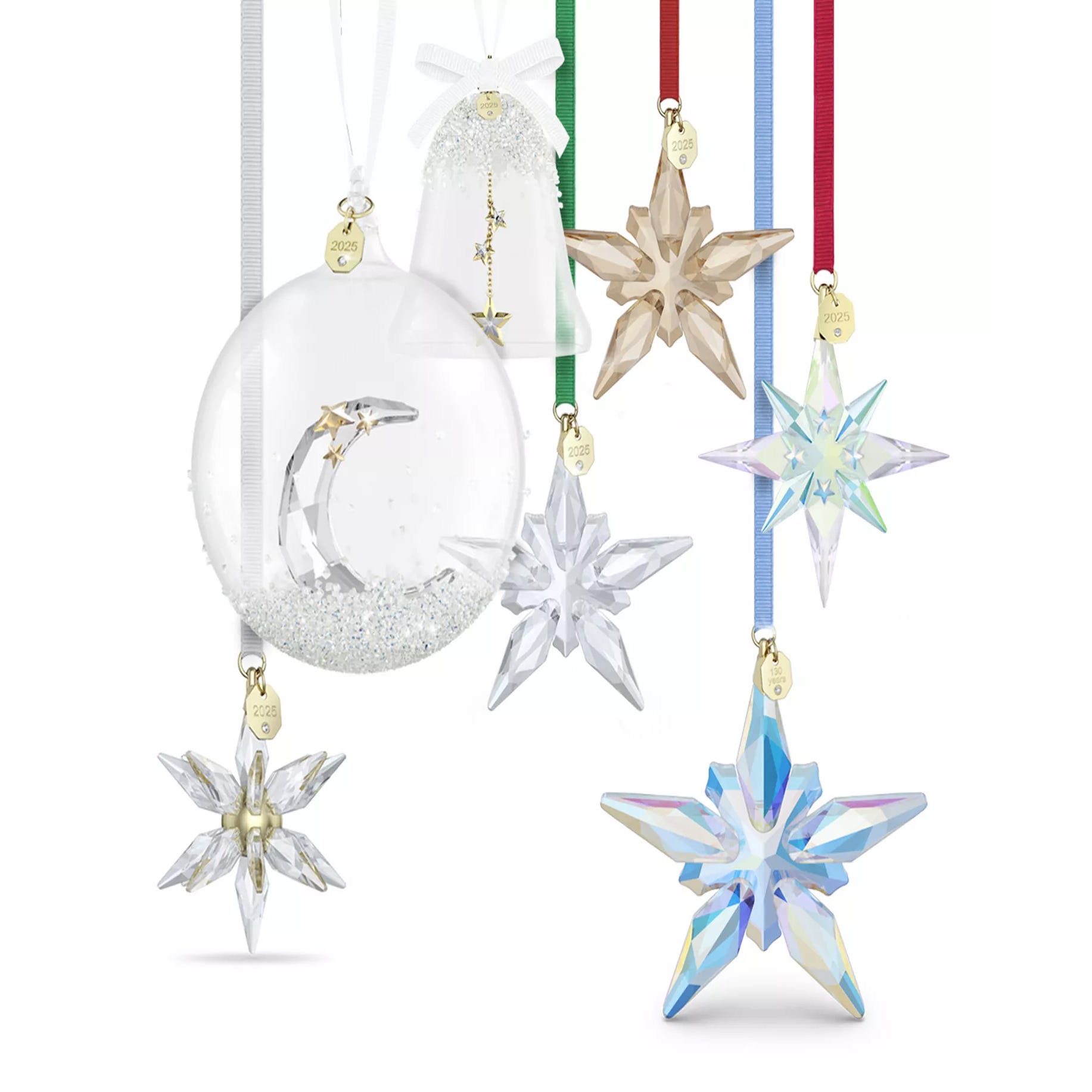 A collection of crystal holiday ornaments featuring star and bell shapes with different colored ribbons and gold year tags, showcasing intricate designs and clear, colored, and iridescent finishes.