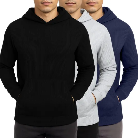 Three men wearing waffle-knit hoodies in black, light gray, and navy blue, each with a front pocket and hood.