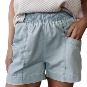 Light blue shorts with an elastic waistband, featuring large front pockets, paired with a textured white top.