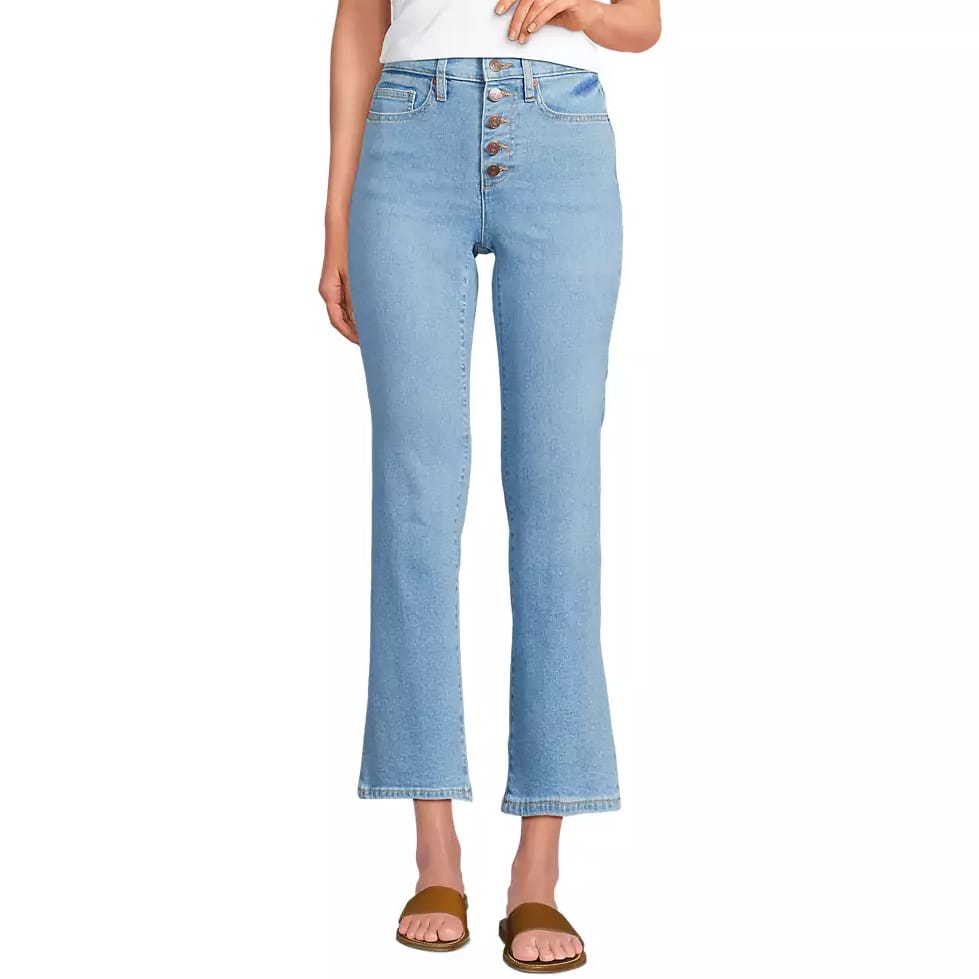 Light wash high-rise jeans with a button-fly closure and a slight flare at the hem. Paired with brown slide sandals.