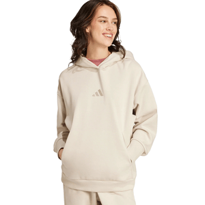 Adidas Oversized Fleece Hoodie in a soft beige color features a minimalist logo on the front, a relaxed fit, ribbed cuffs, and a spacious front pocket.