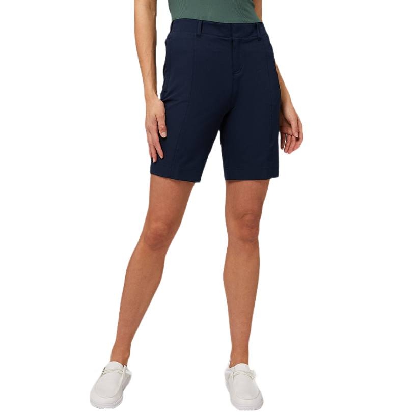 Navy blue knee-length shorts worn with white sneakers and a green top.