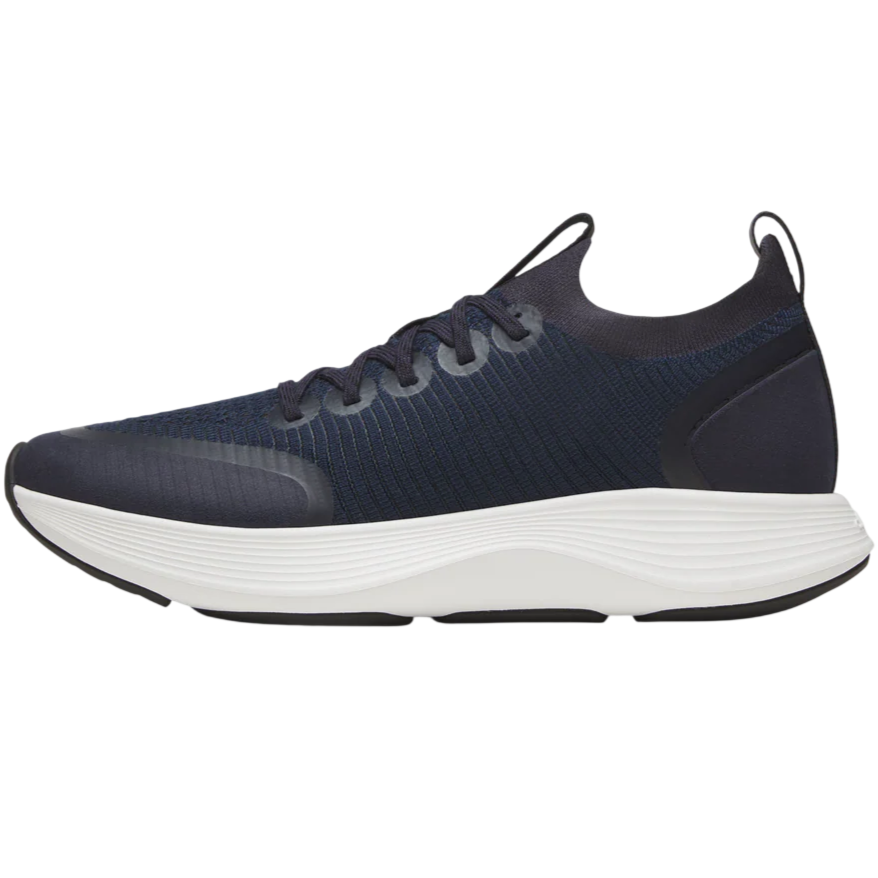 A navy athletic shoe with a textured upper and white cushioned sole, featuring laces and a pull tab at the heel.