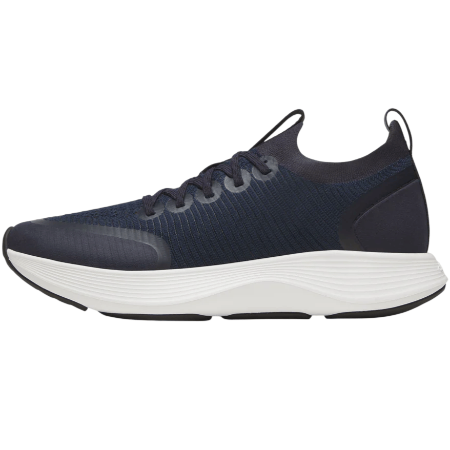 A navy athletic shoe with a textured upper and white cushioned sole, featuring laces and a pull tab at the heel.