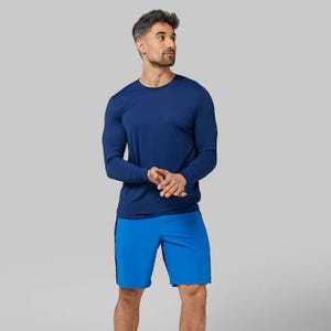 A man is wearing a long-sleeve blue athletic shirt and matching blue shorts.