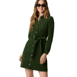 A woman wearing a green long-sleeve button-up dress with a tied waist and sunglasses.