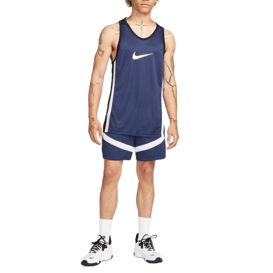 Navy blue Nike Dri-Fit basketball shorts with white diagonal stripes, designed for comfort and performance. They are paired with a matching navy tank top, featuring a prominent white Nike swoosh.