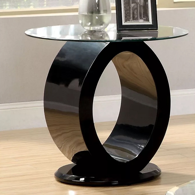 A modern side table with a circular black base and an oval open design, topped with a round glass surface.