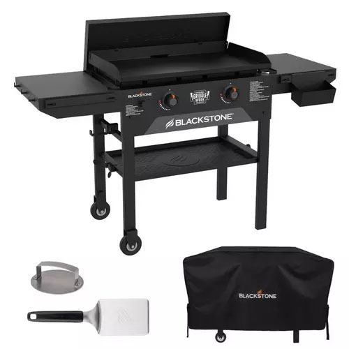 Blackstone outdoor griddle with dual burners, adjustable legs, side shelves, and a grease tray, accompanied by a spatula, a meat press, and a protective cover.