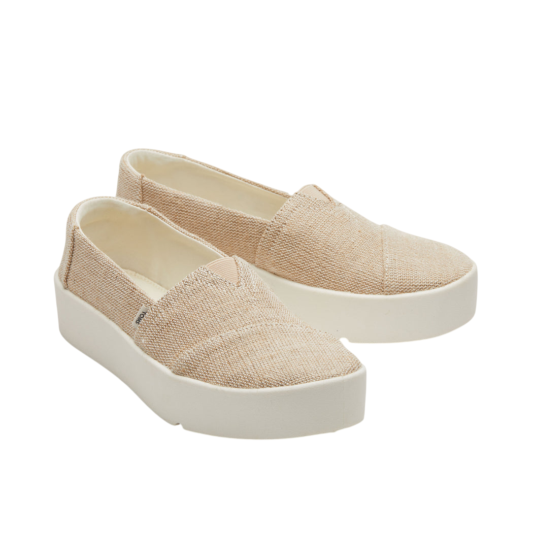 Beige slip-on shoes with a textured fabric upper and thick white soles.