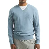 A man is wearing a light blue V-neck sweater over a white T-shirt, paired with light gray pants. The sweater has a small logo on the chest.
