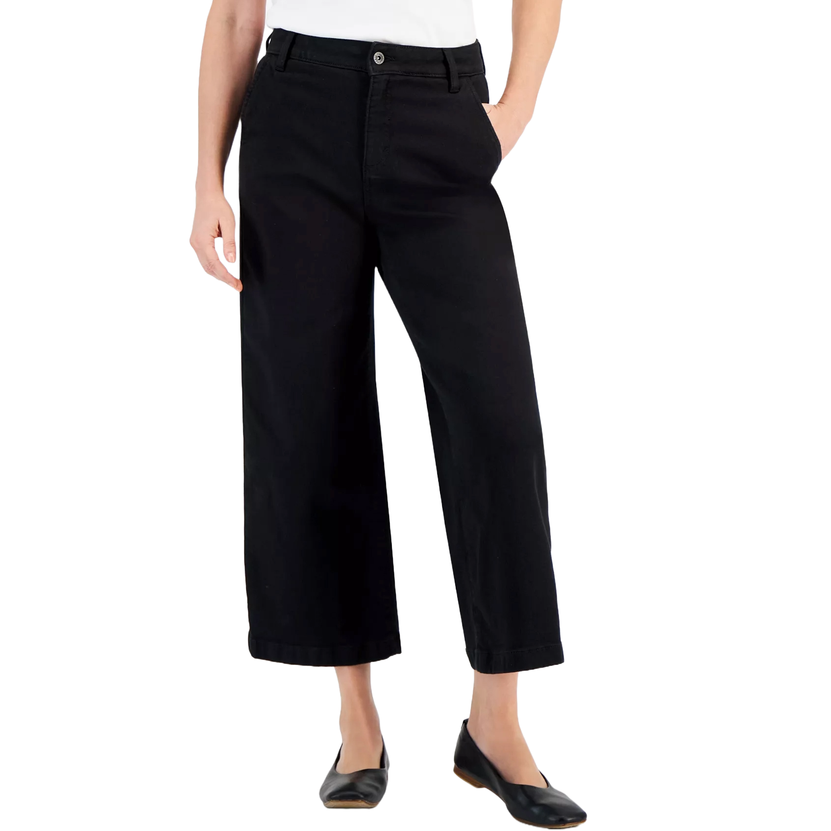 A person is wearing black wide-leg ankle-length trousers with a white top and black flat shoes.