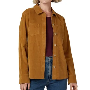 A woman is wearing a mustard-colored corduroy shirt with button closure and chest pockets, paired with blue jeans and a maroon top underneath.