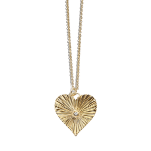 A gold heart-shaped pendant with a radiant, textured design and a small center gemstone, hanging from a delicate gold chain.