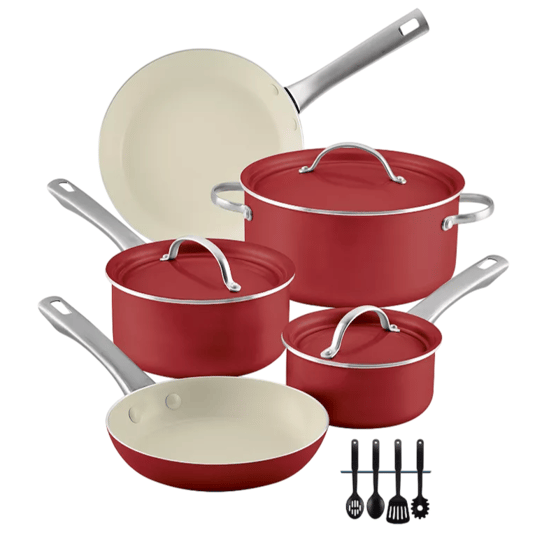 Cookware set featuring red pots and pans with lids, stainless steel handles, non-stick white interiors, and black kitchen utensils including a spatula, ladle, and pasta server.