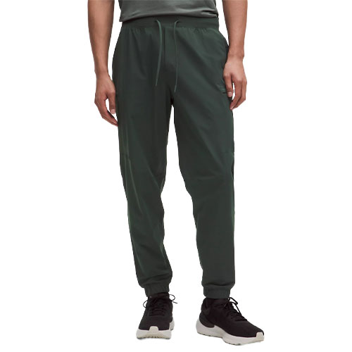 Dark green jogger pants with a drawstring waist and elastic cuffs, paired with black and white sneakers.