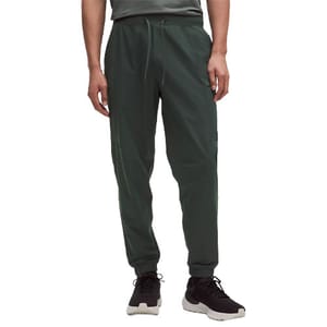 Dark green jogger pants with a drawstring waist and elastic cuffs, paired with black and white sneakers.
