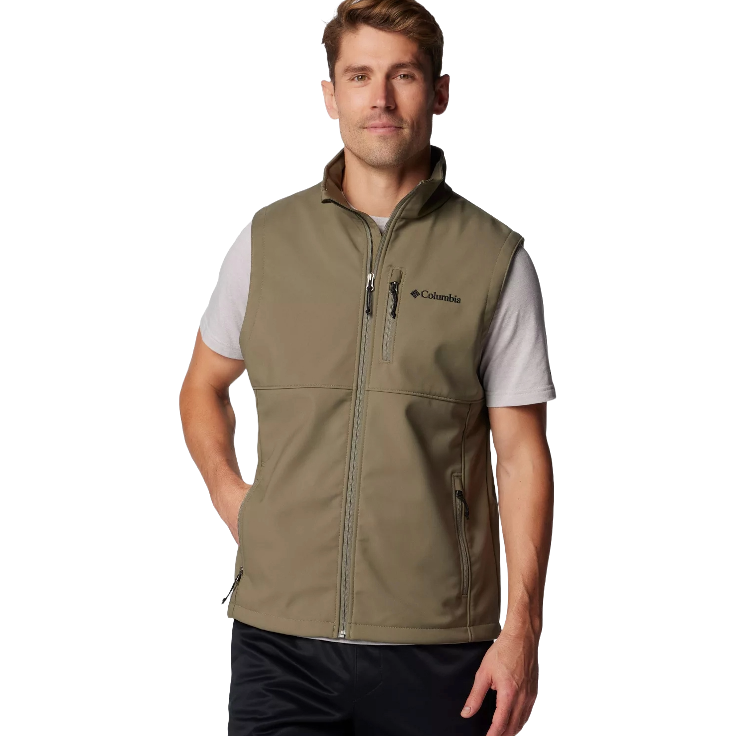 A man wears a Columbia olive-green zip-up vest with a chest and side pocket, layered over a short-sleeve t-shirt.