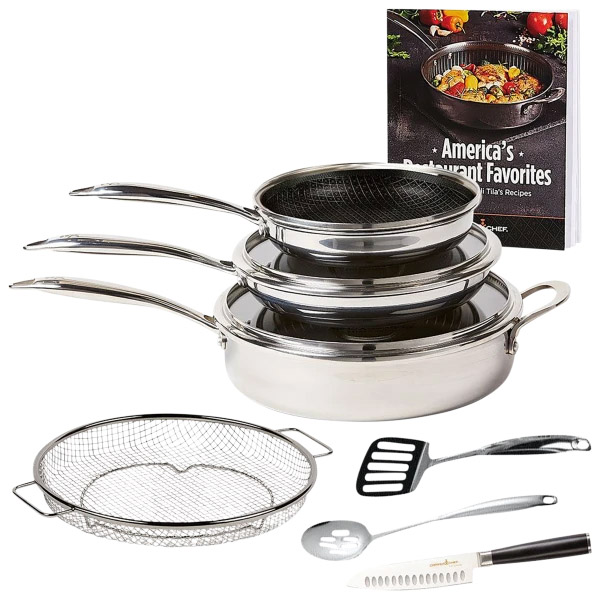 Stacked stainless steel cookware set with a mesh strainer, two spatulas, and a cookbook.