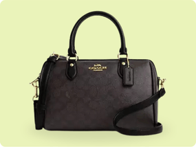 A Coach handbag featuring a dark brown leather body with a subtle logo pattern, gold-tone hardware, dual handles, and an adjustable shoulder strap.