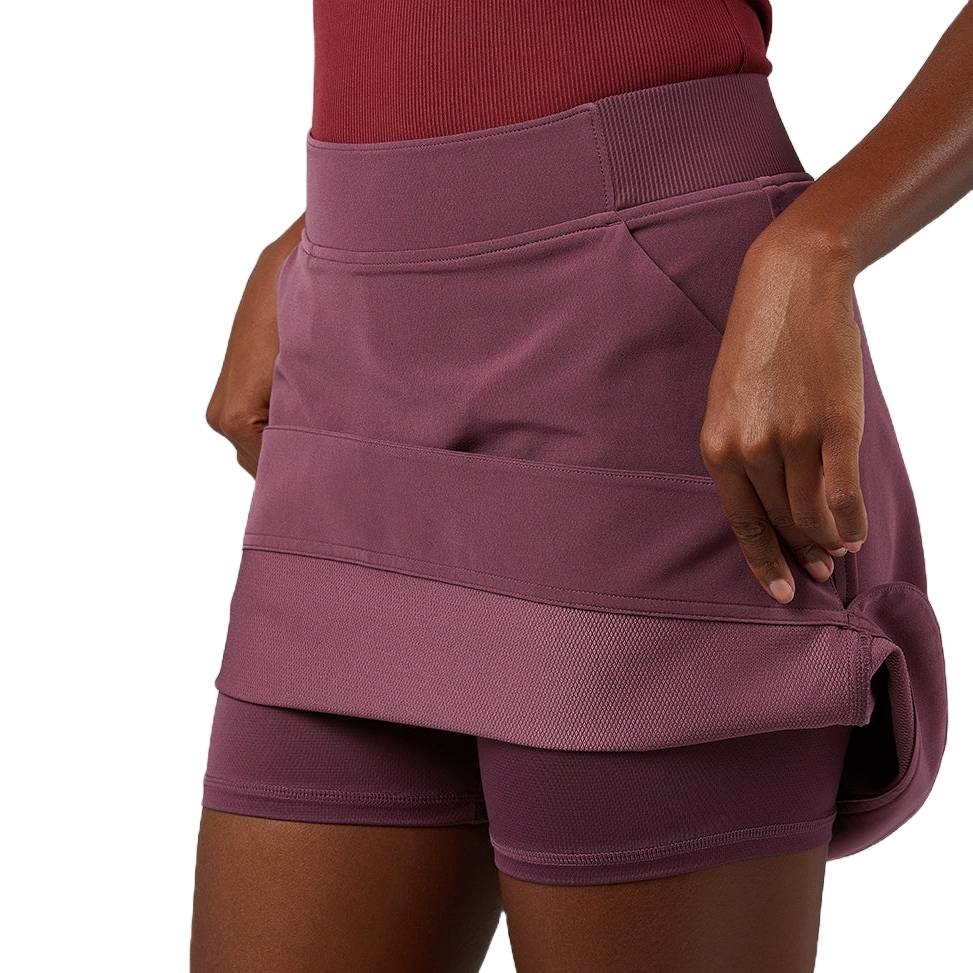 A maroon athletic skirt with an inner layer of shorts and a ribbed waistband, ideal for sports or casual wear.