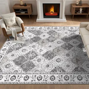 A living room features a patterned area rug with a floral and geometric design, placed between two armchairs and a sofa, in front of a lit fireplace.