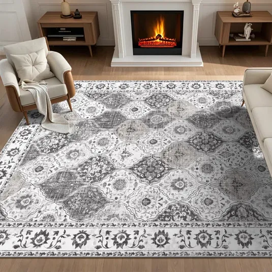A living room features a patterned area rug with a floral and geometric design, placed between two armchairs and a sofa, in front of a lit fireplace.