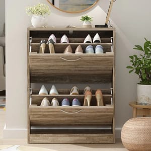 Wooden shoe storage cabinet with three tilt-out drawers, each holding four pairs of shoes. The compact design includes a light brown finish, curved handles, and decorative items on top.
