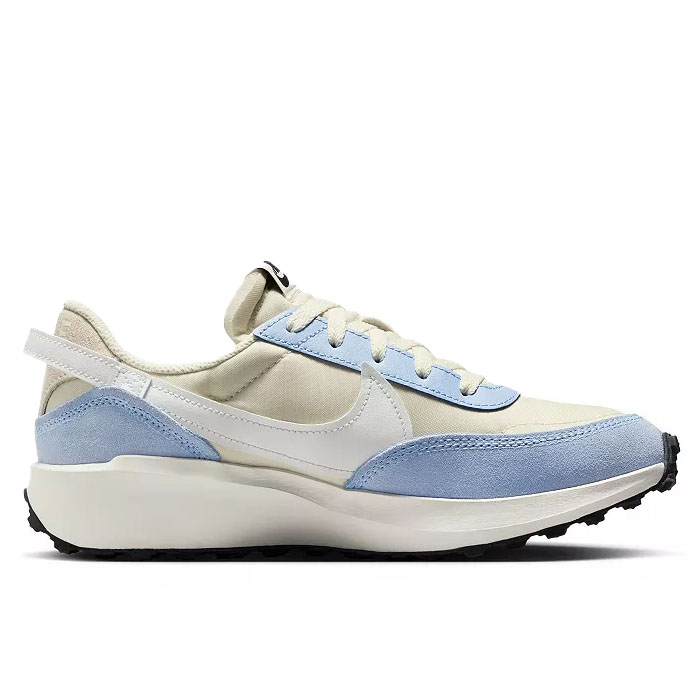 A light blue and cream sneaker with a white swoosh and beige laces, featuring a textured sole and a cushioned collar for comfort.