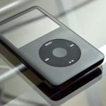 An iPod Classic with a click wheel interface, displayed on a reflective surface.