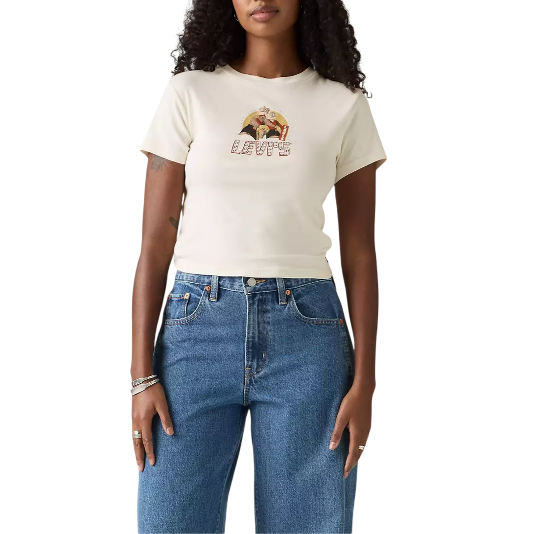A woman wearing a cream Levi's graphic T-shirt paired with high-waisted blue jeans.