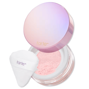 Tarte loose setting powder in a pink-toned container with a gradient lid and a white applicator puff labeled with the Tarte logo.