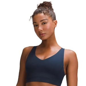 The Envital Bra is a sleek, dark-colored sports bra with a V-neckline and broad, supportive straps, designed for comfort and style during workouts.