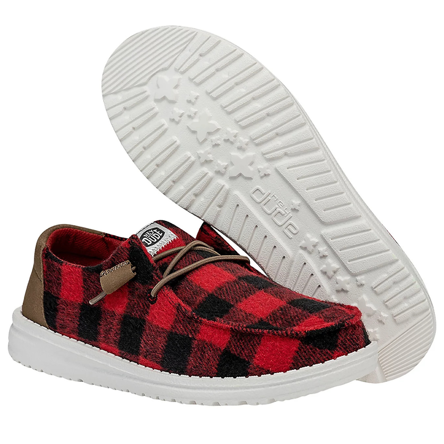 Hey Dude Wendy Buffalo Plaid Shoes feature a red and black checkered pattern with white soles and brown accents. They have a soft fabric upper, comfortable fit, and a lightweight design with distinctive tread on the soles.