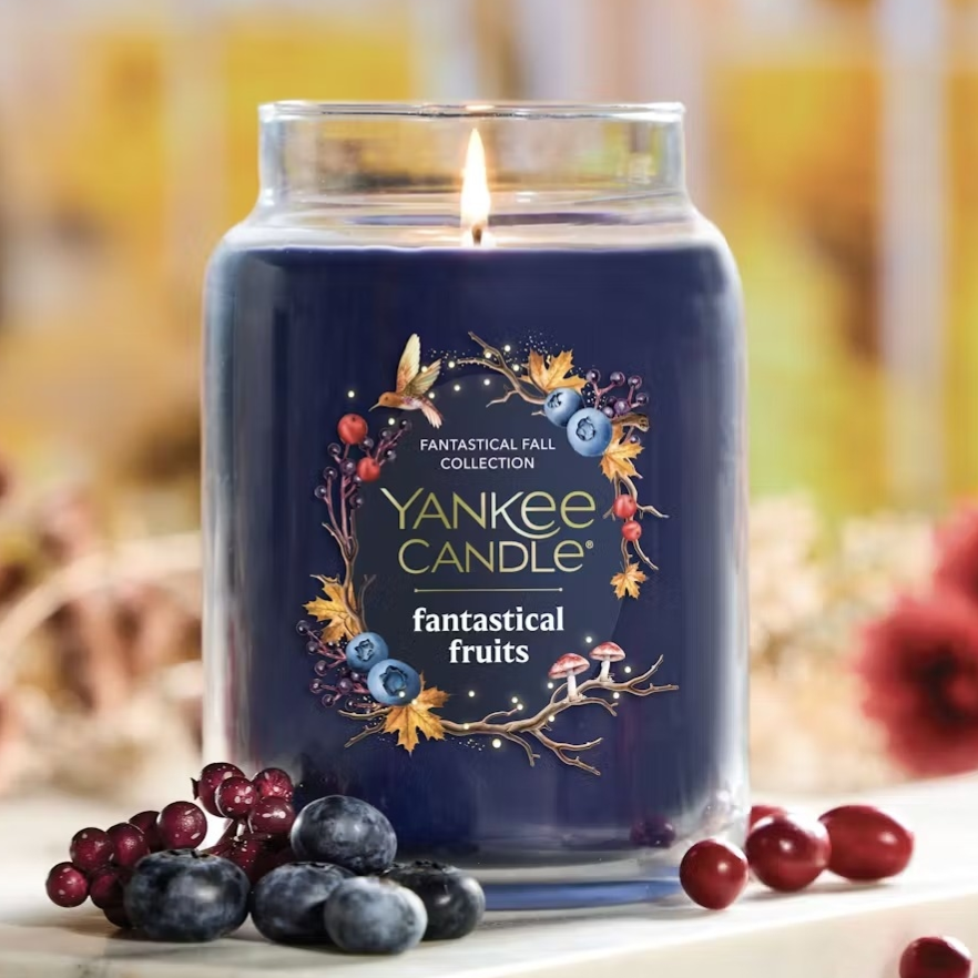 Yankee Candle from the Fantastical Fall Collection featuring \“Fantastical Fruits\“ scent, with blueberries and cranberries nearby.