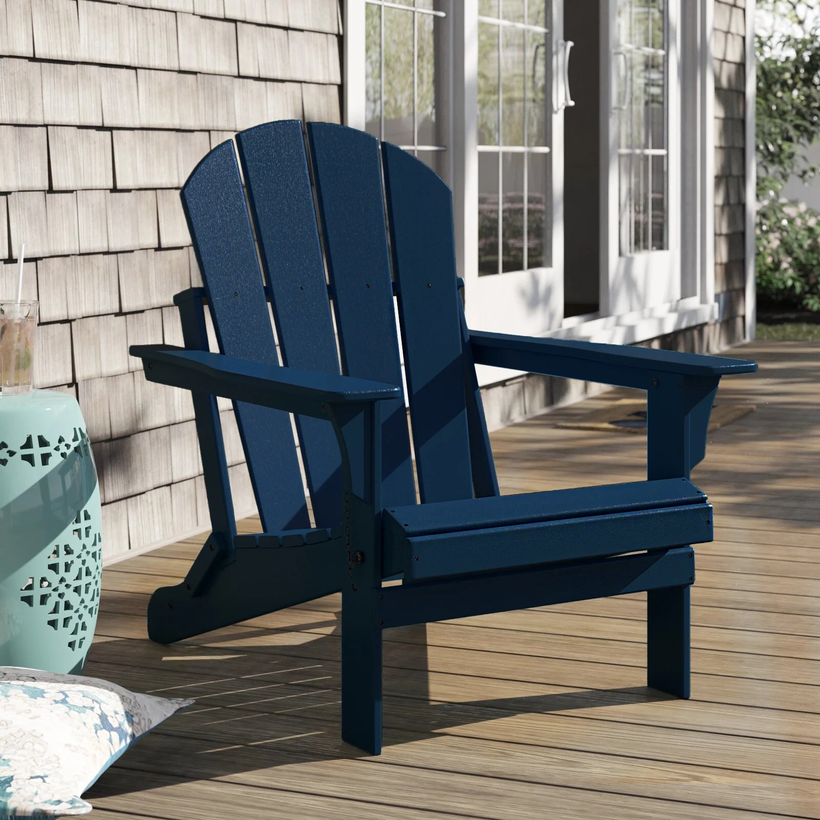 A blue Adirondack chair on a wooden deck.