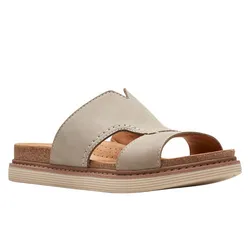 A beige slide sandal with an open-toe design, featuring a crisscross leather upper and a cork footbed for added comfort. The sole has a low, textured platform.